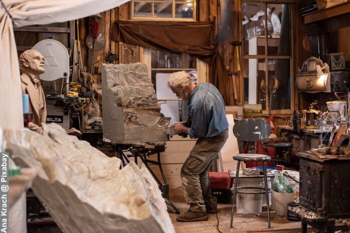 Unique working routines by an old man artist in a studio doing art sculpture at his workshop