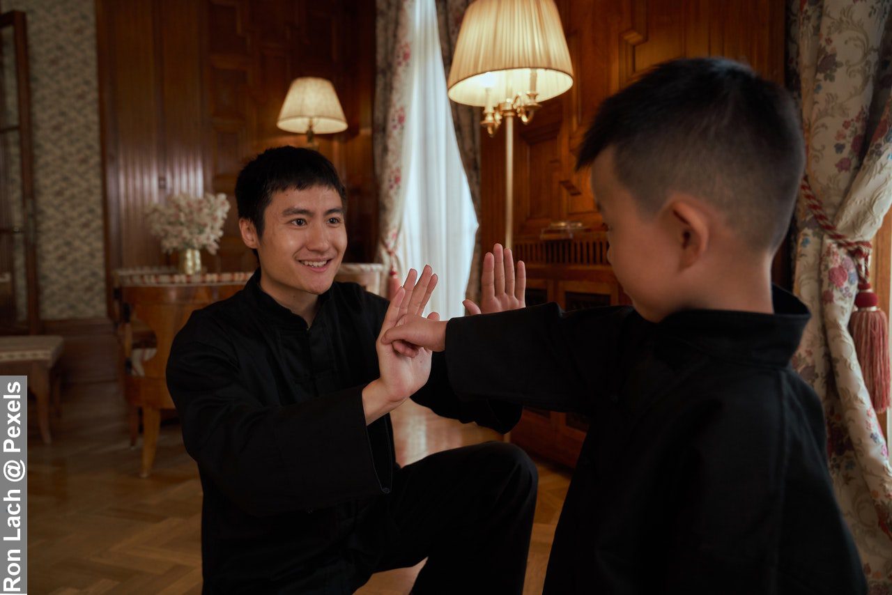 Father making exercise fun for kids, practicing martial arts with son