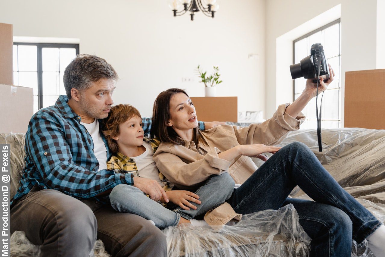 Family photography with mum taking picture with her family while sitting on the sofa