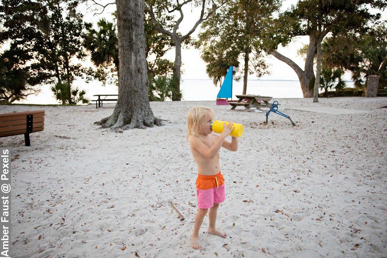 Boy Drinking With Yellow Bottle in Hot Weather