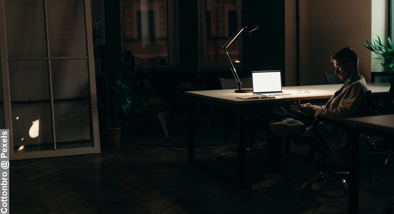 Poor effort balancing work and family, as young man works late into the night at work