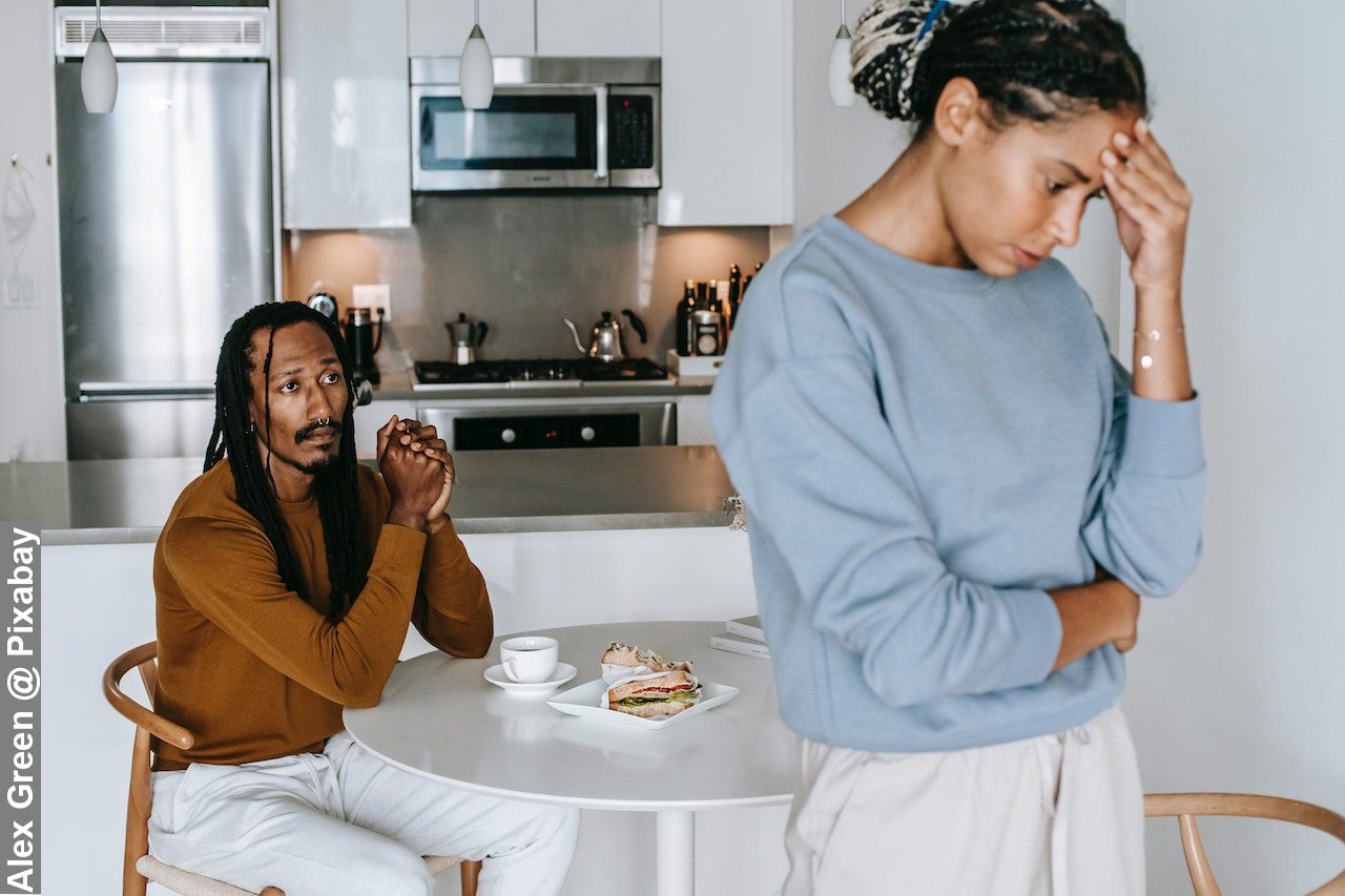 Black couple having conflict in the kitchen in need possibly of a divorce lawyer