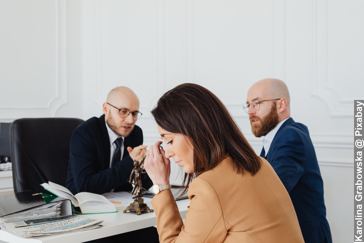 Sad woman sitting next to the bearded man husband with divorce lawyer