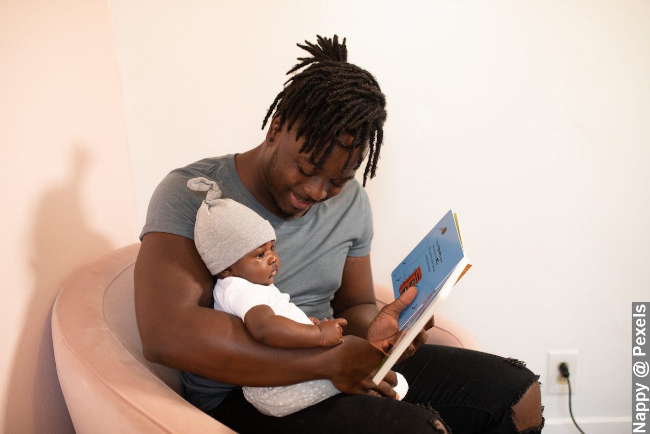 Facts About Fathers with black dad carrying baby and reading to them