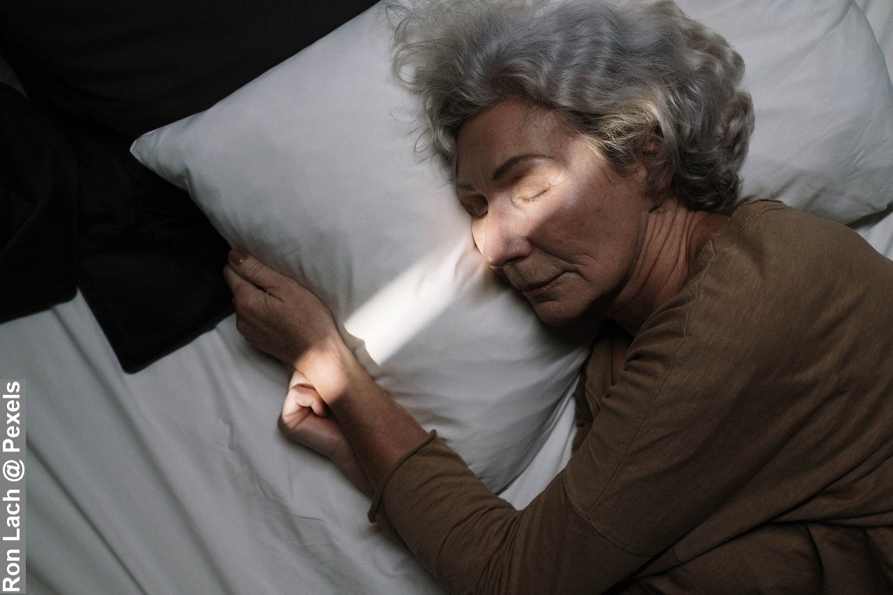 An elderly woman sleeping in bed showing science of sleep