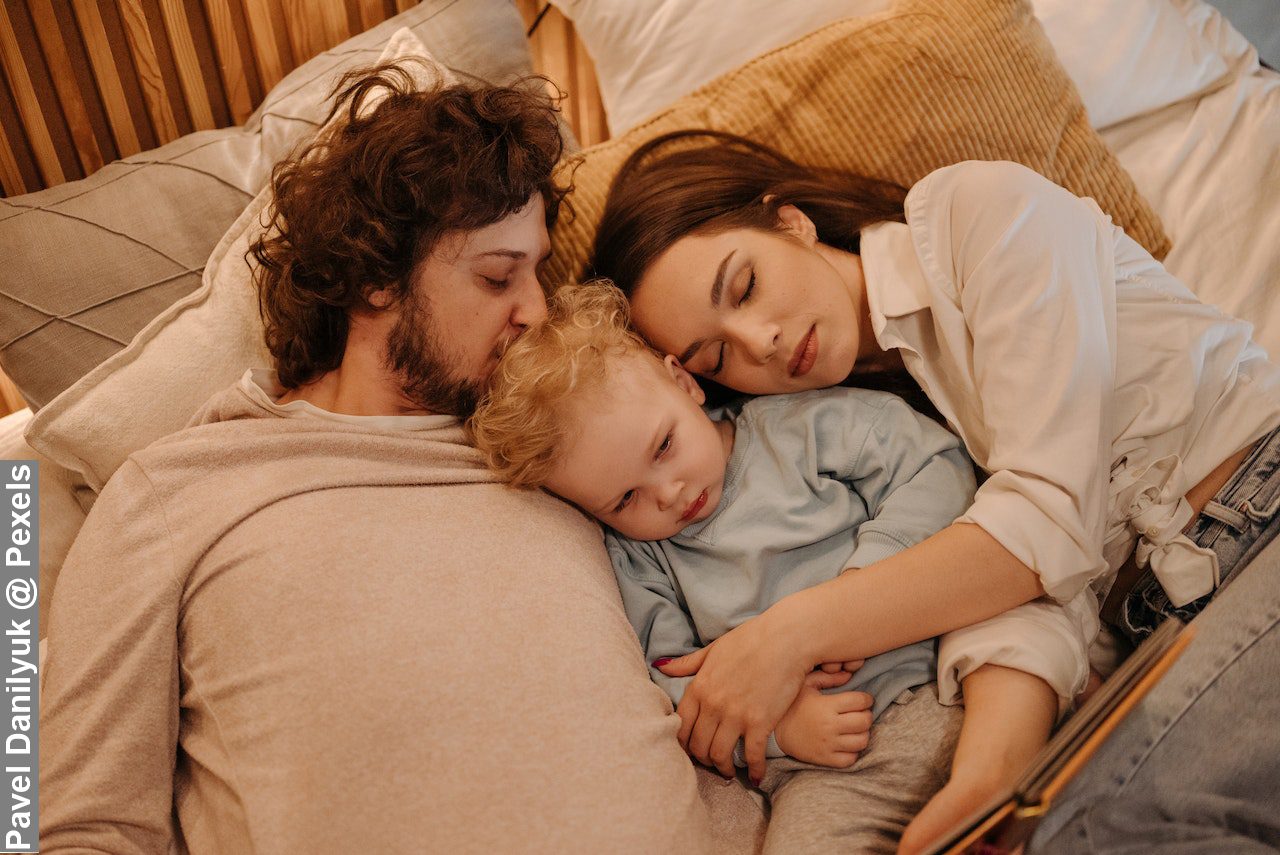 Family lying on bed together