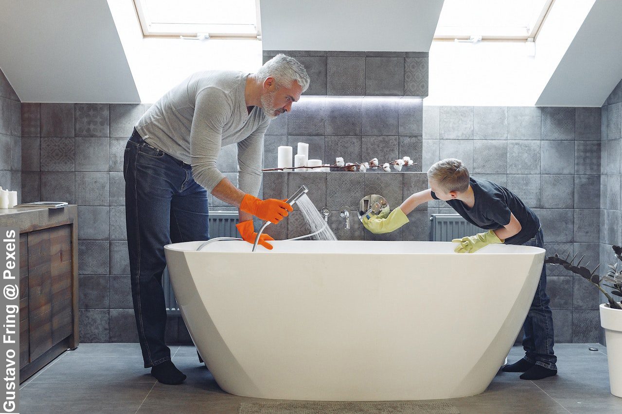 Teaching kids helping around the house is what this father is doing. Father and son tidying up bathroom together