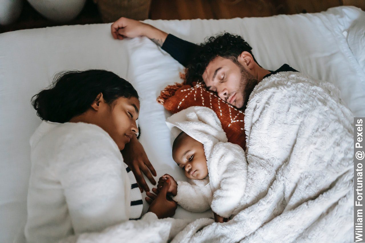 Tranquil multi-ethnic family sleeping on bed in morning