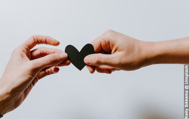 Perfectionism in a relationship, man and woman holding a black heart together