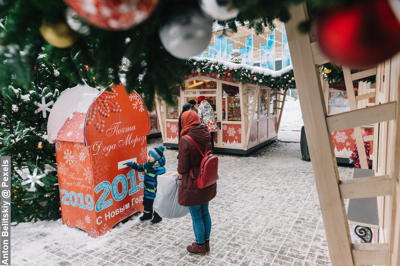 Christmas Holidays with Kids, toddler and Mum standing at market booth in snow