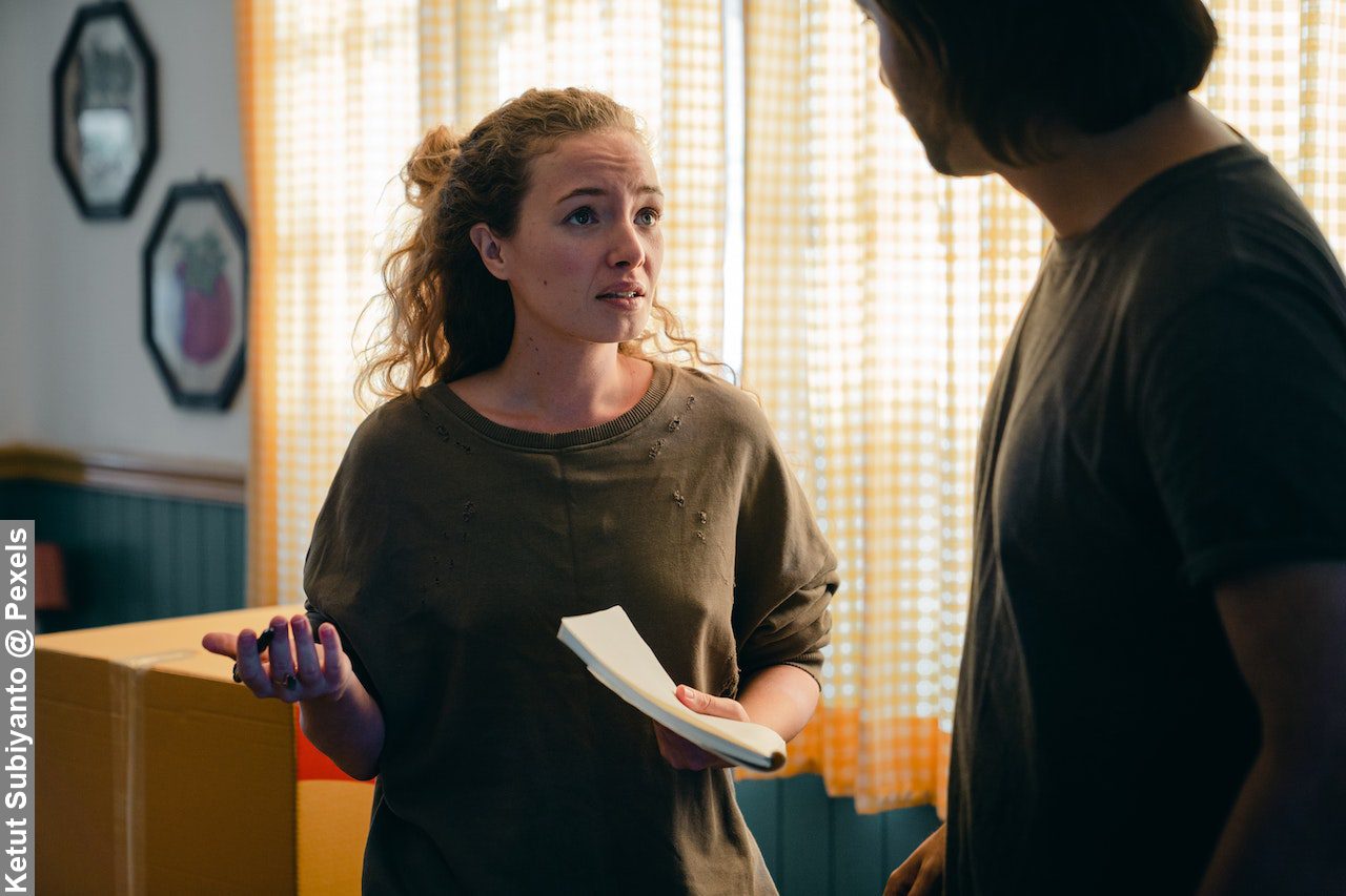 Couple talking about family finances in kitchen trying to cut costs as a family