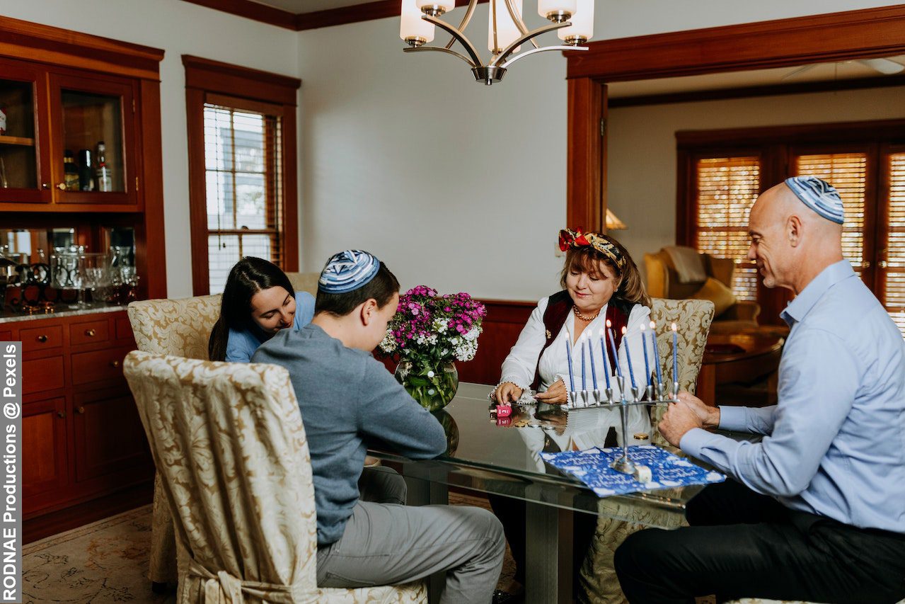 Family playing dreidel together on dining table