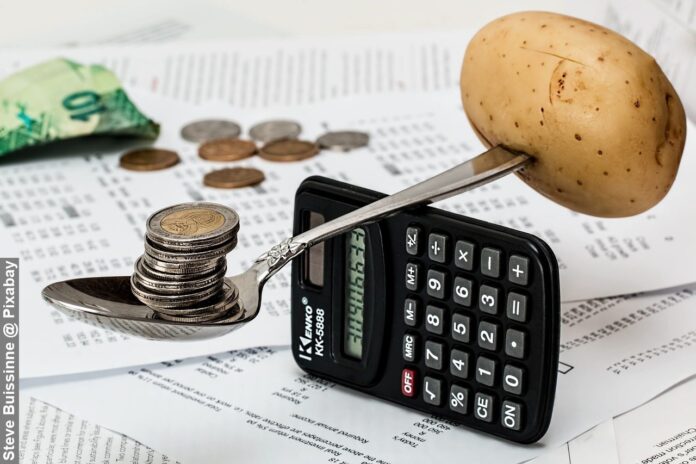 Household budget money with coins and calculator balancing