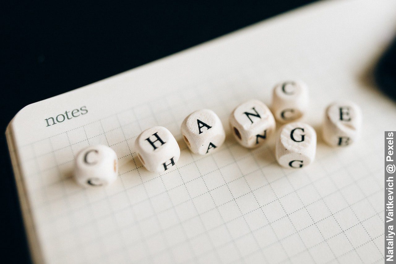 A close-up shot of change in letter dice on an open notebook, indicting the need to embracing change