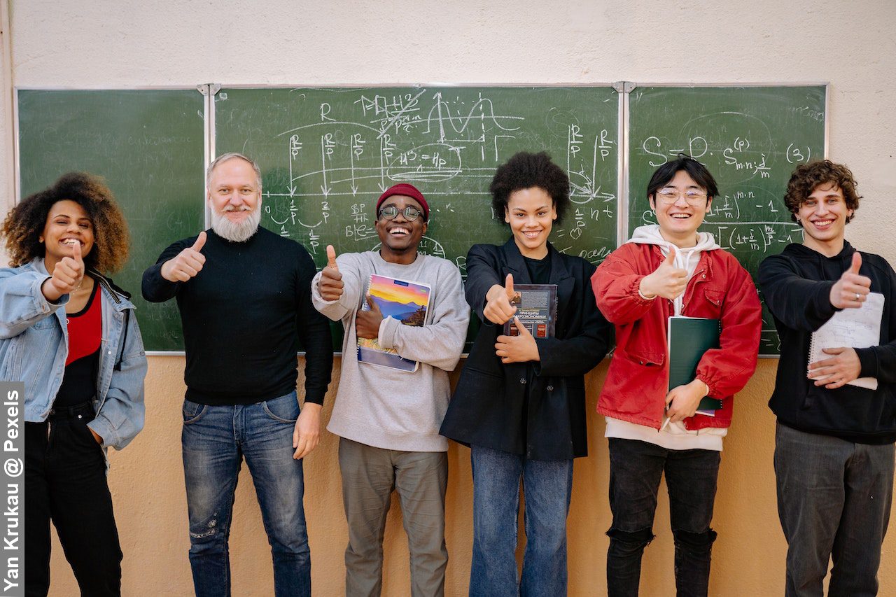 Diversity in higher education, professor stood in front of greenboard with his Students