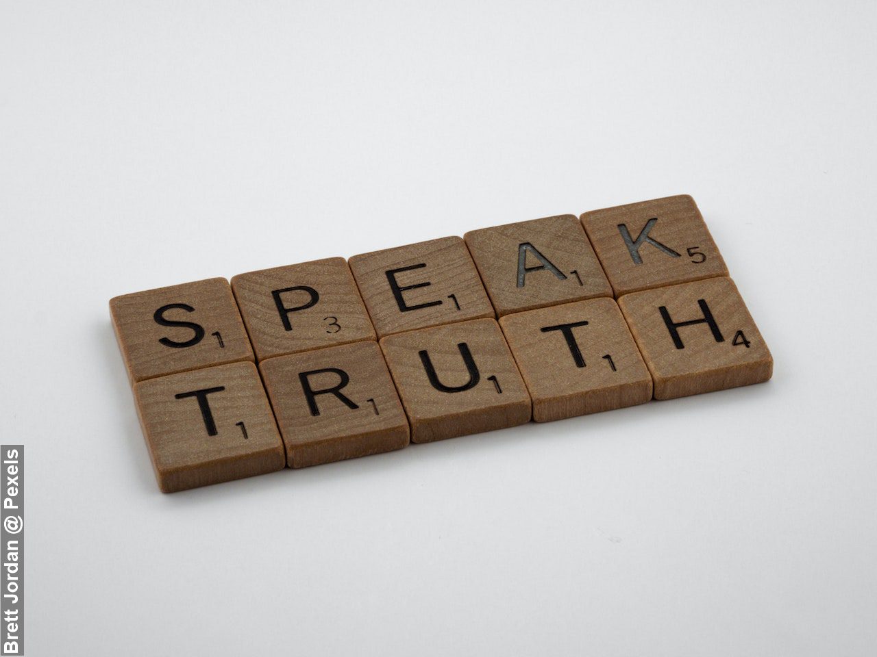 Keeping it Real by speaking the truth. Speaking Truth written on brown wooden blocks on white surface