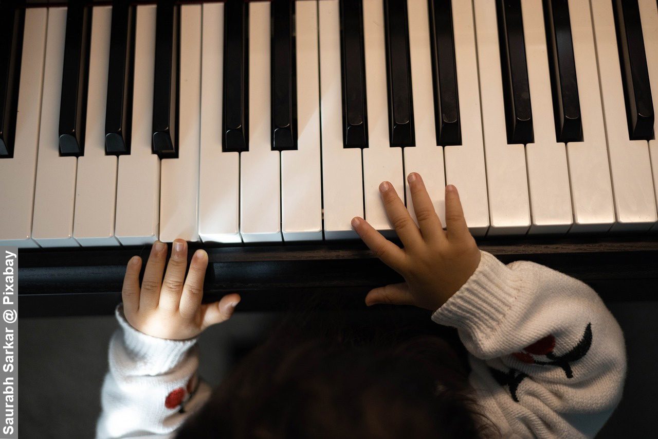 Female girl fingers on piano keys