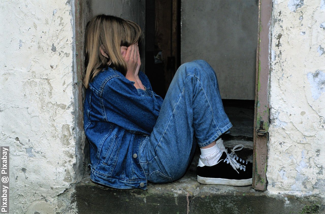 Lonely girl sitting on a doorway in need of support from a foster carer’s boundless heart