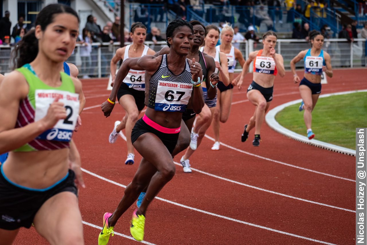 Diverse group of athletes on athletics track racing, that shows athletes from different backgrounds or with different physical abilities can represent inclusivity in sports.