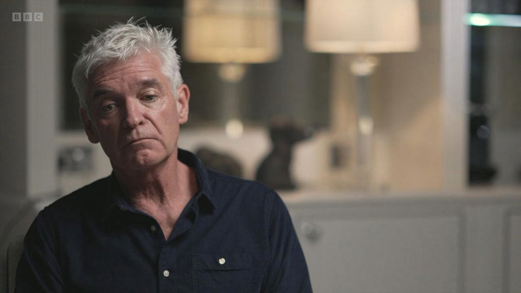 Close-up shot of Philip Schofield looking visibly sad, lips sucked in and face relaxed.