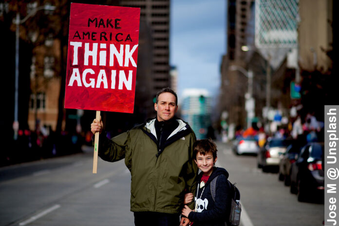 Freedom of speech is a right in America, boy and dad holding a placard protesting