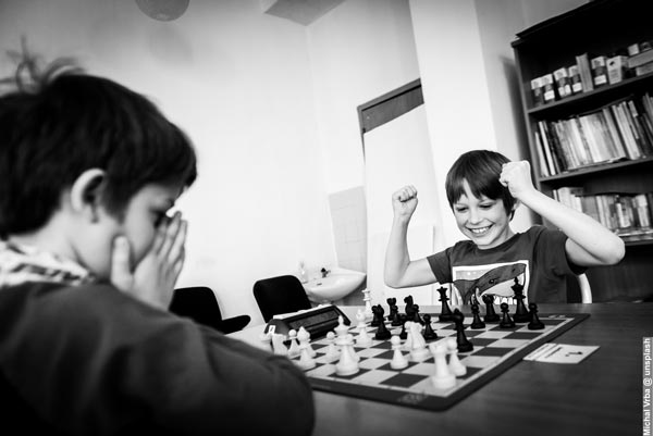 Two Boys Playing Chess in Black and White